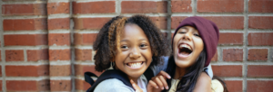Two students hugging and laughing