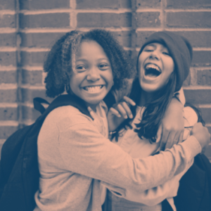 Two students hugging and laughing