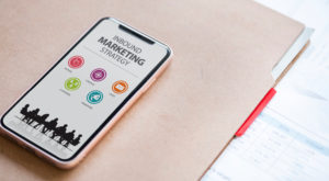 cell phone sitting on a folder with saying Inbound Marketing Strategy on screen