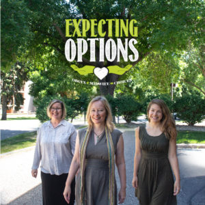 Three smiling women walk outdoors beneath large trees with the text "Expecting Options: OBGYN + Midwife = Choices" displayed above them, promoting maternity care options.