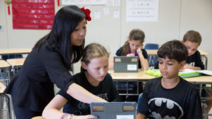 young students learning in a classroom on ipads