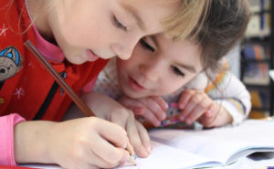 2 girls drawing on paper