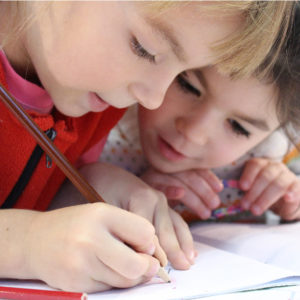 2 girls drawing on paper