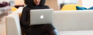 Person working on laptop while sitting on a sofa