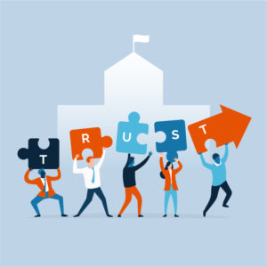An illustration of six people holding up puzzle pieces and an arrow, spelling out the word "TRUST." They stand in front of a building, symbolizing teamwork and collaboration.