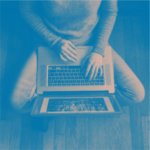 person using laptop on floor