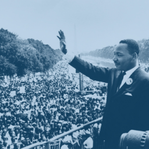 Martin Luther King Jr. waves to a large crowd during the 1963 March on Washington, with the Washington Monument visible in the background.
