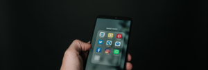 A person holding a phone with social media apps on the screen