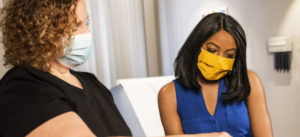 Two women wearing COVID masks