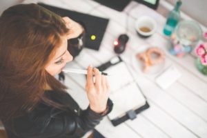 Young woman at a desk with a pen
