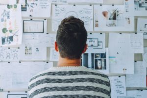 Person staring at wall of documents