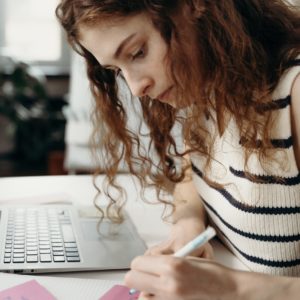 woman taking notes while working