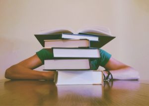 a stack of books with a person behind them