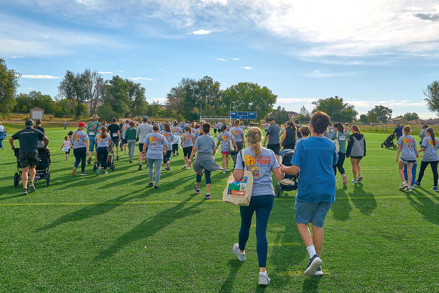 start of the community 5k foster the future everyone wearing t-shirts on football turf