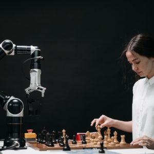 Woman playing chess against an AI chess robot