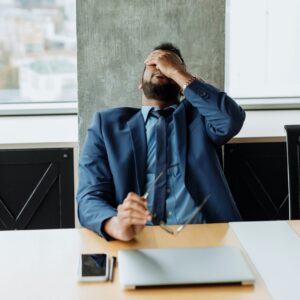 a man leaning back with his hand on his forehead
