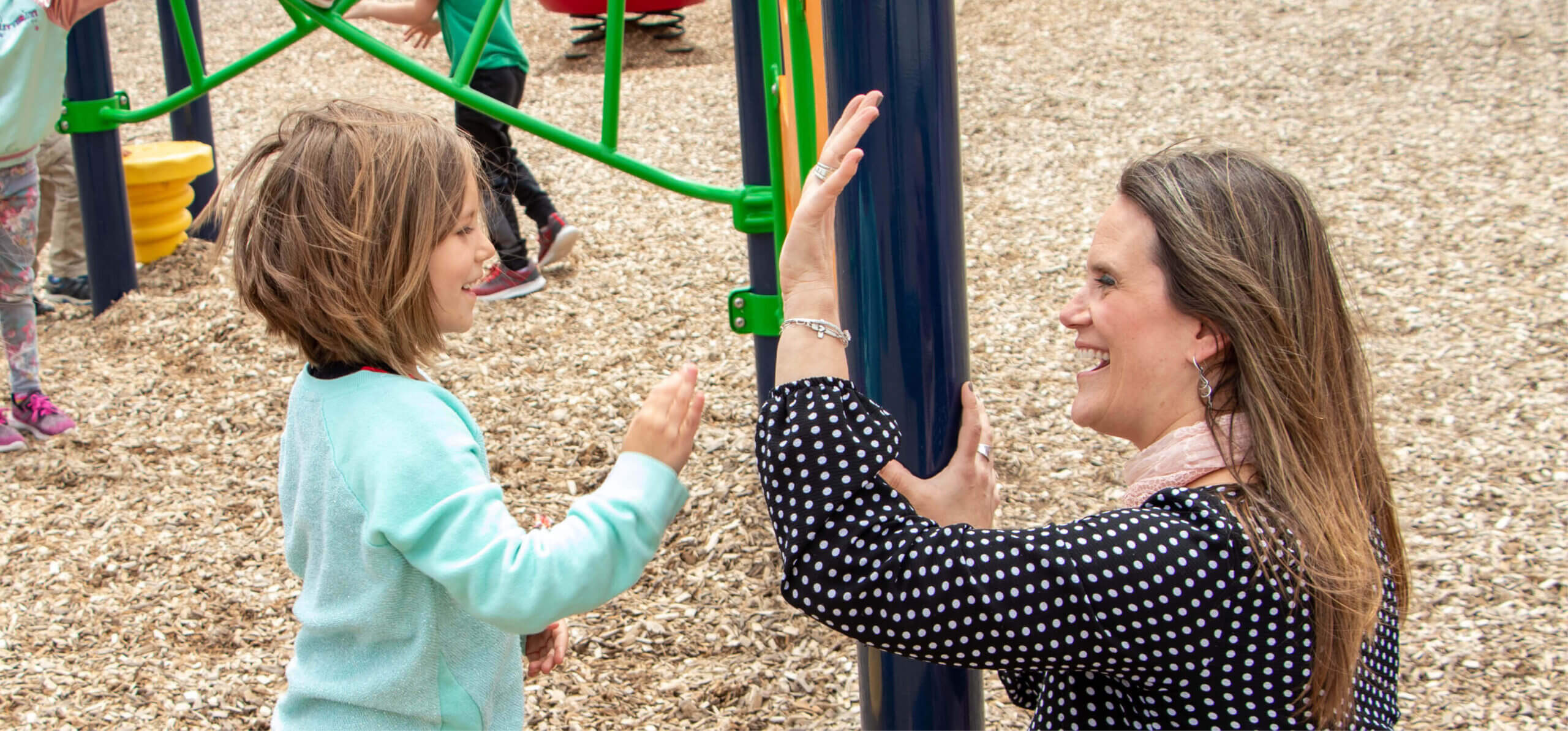 principal at princeton elementary celebrating with student on playground