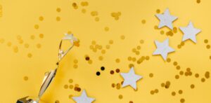 Yellow background filled with gold glitter, silver stars, and a golden trophy