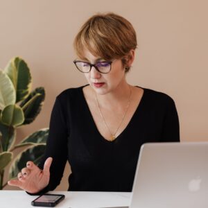Person looking at their phone and laptop