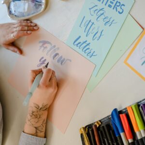 Hands writing words in different fonts