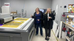 anna and chelsea at the printer with Osseo Area School Thank You Signs for referendum