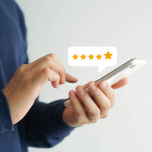 A person leaving a five star online review on their mobile phone.