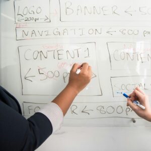 Person Holding Marker writing on whiteboard
