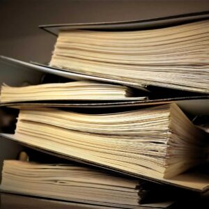 A stack of school board policy binders that are not translatable or accessible