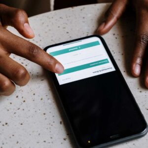 Person downloading a PDF onto their small mobile phone screen.