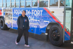 Student walking past custom wrapped bus