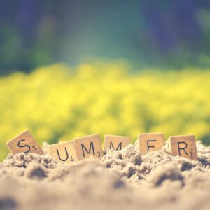 Scrabble Tiles spelling out Summer in the sand