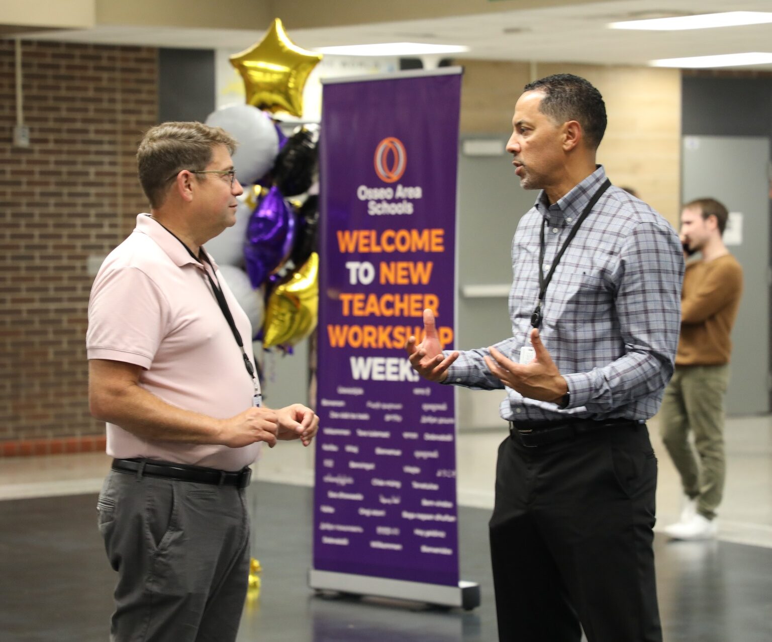 Teachers with branded banner in background