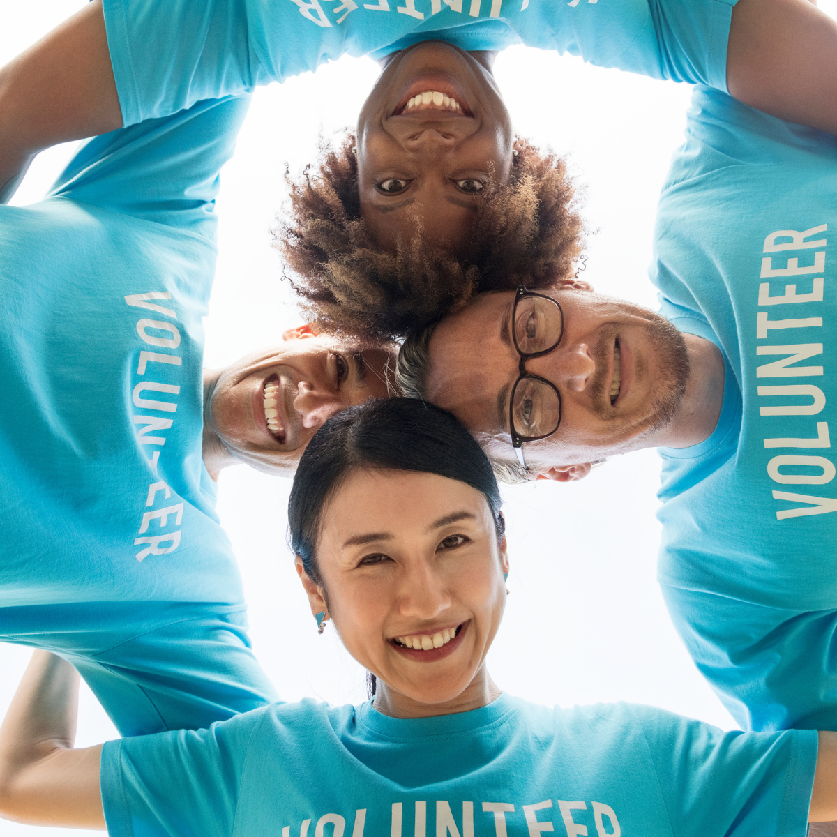 Four nonprofit volunteers with their arms around one another